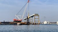 Two years after the Francis Scott Key Bridge collapsed, the Weeks 533 crane drives a pile beneath the Patapsco River on the site of a new bridge. (Dan Belson/The Daily Record)