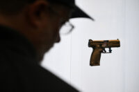 A person looks at a gun on display during the National Rifle Association’s (NRA) Annual Meetings and Exhibits in Houston, Texas, U.S. April 19, 2026. REUTERS/Callaghan O'Hare