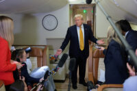 U.S. President Trump speaks to reporters mid-flight in the press cabin of the new Air Force One
